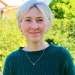 Blonde junge Frau in grüne Pulli.