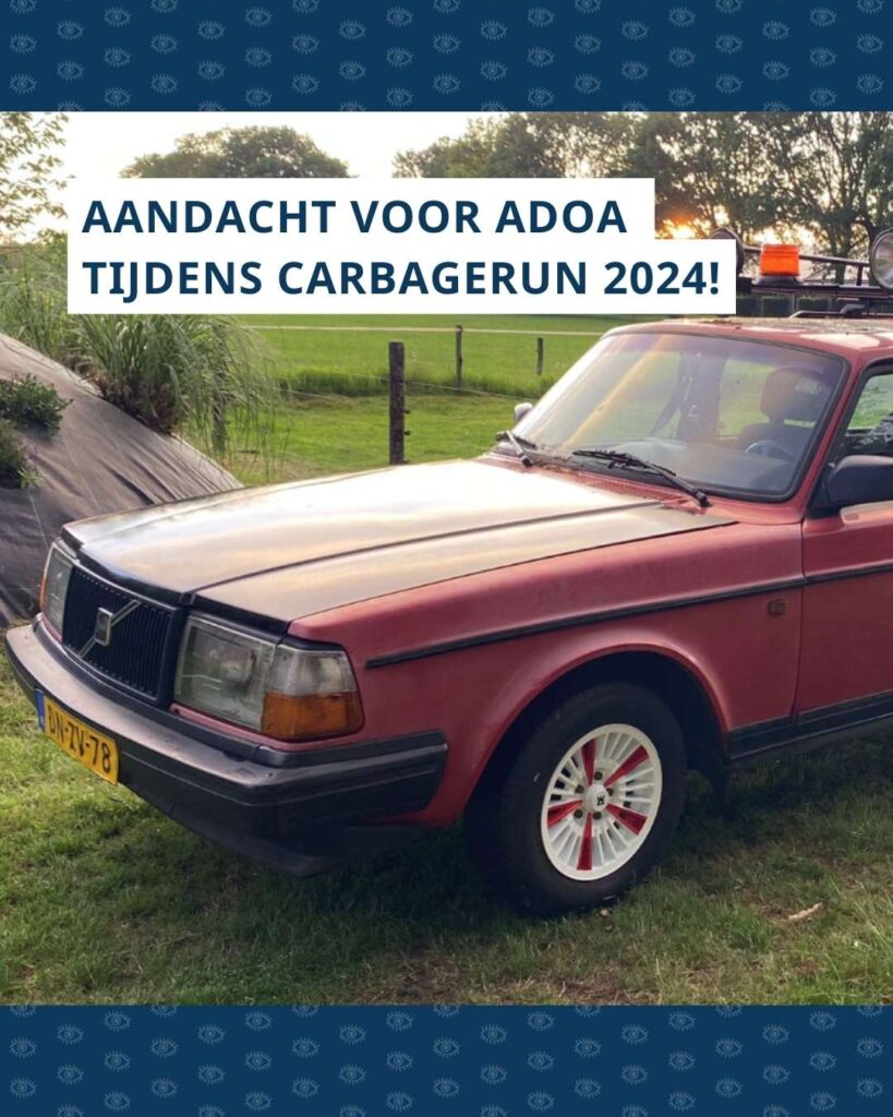 Een oude rode Volvo op een boerenerf. Erboven de tekst AANDACHT VOOR ADOA TIJDENS CARBAGERUN 2024!