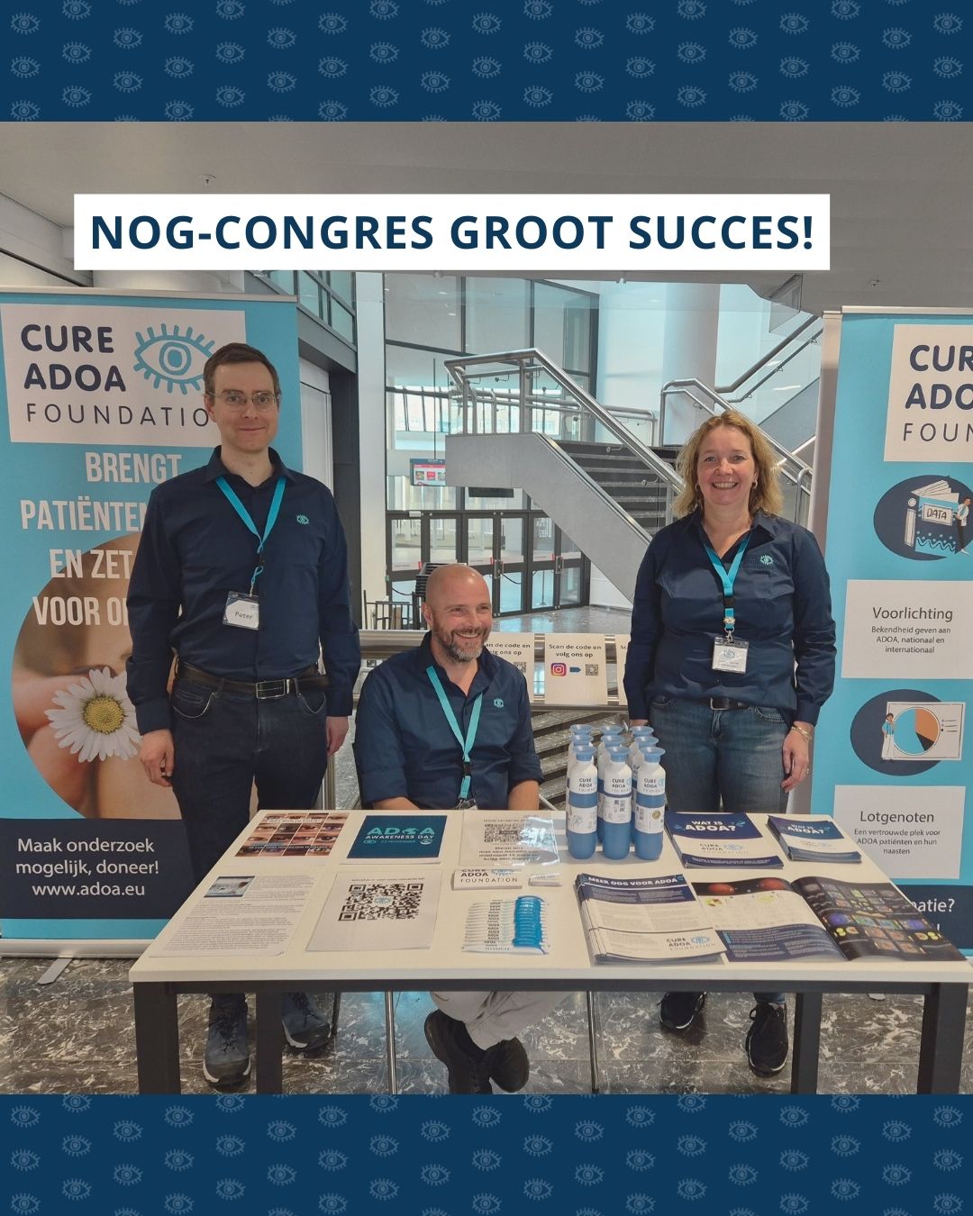v.l.n.r. Peter, Richard en Hedy achter een tafel met promotiemateriaal van de Cure ADOA Foundation. Links en rechts van hen staan grote banners met informatie over de Cure ADOA Foundation. Bovenin de foto staat de tekst ‘NOG-congres groot succes!’