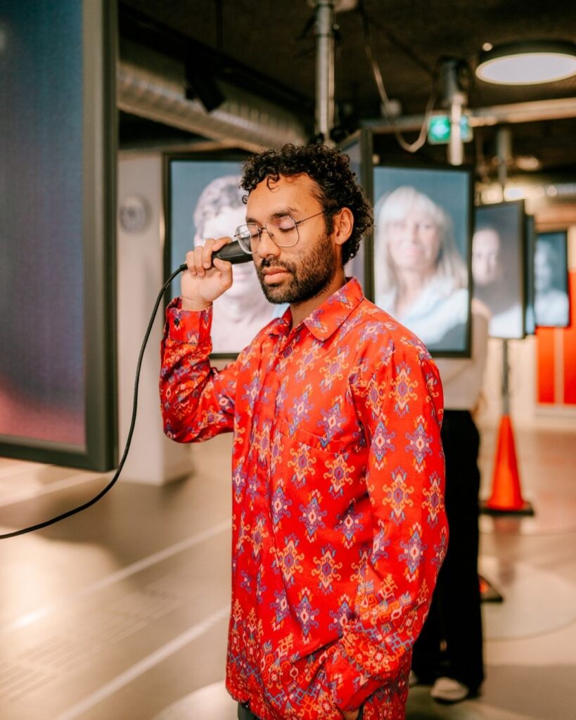 Bezoeker muZIEum luistert met ogen dicht naar ervaringsverhaal.