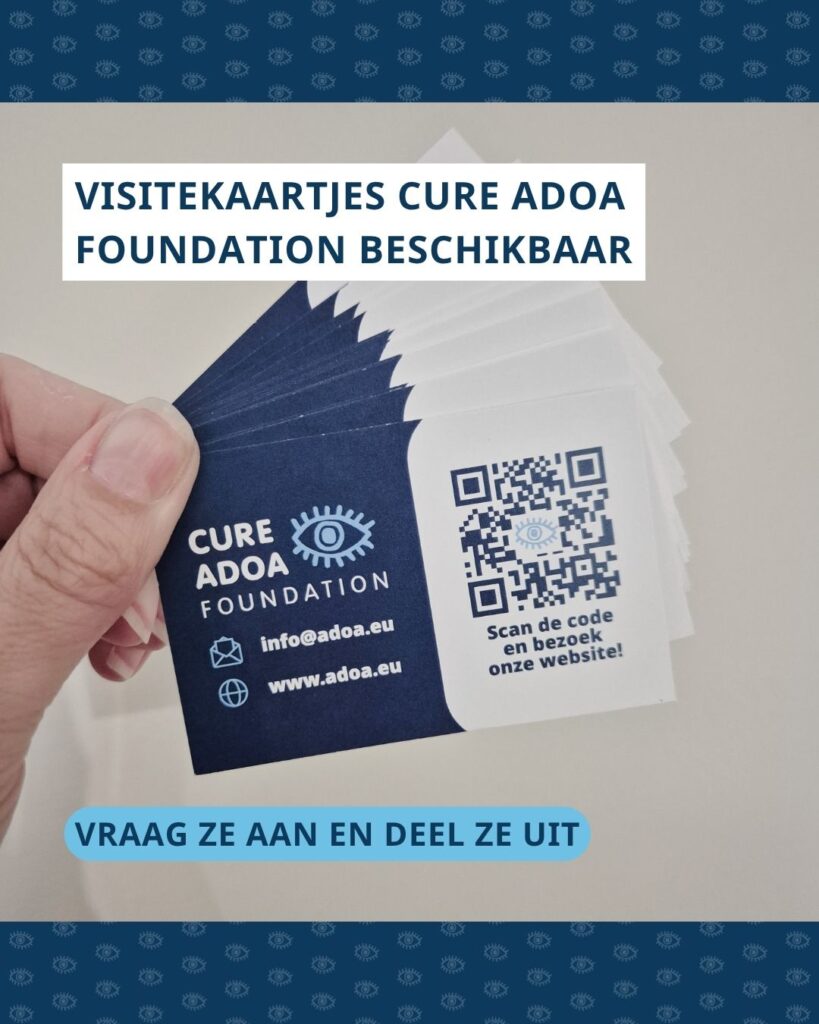 Hand met visitekaartjes Cure ADOA Foundation in waaier. Bovenin de foto staat de tekst ‘Visitekaartjes Cure ADOA Foundation beschikbaar’ en onderin de foto ‘vraag ze aan en deel ze uit’.