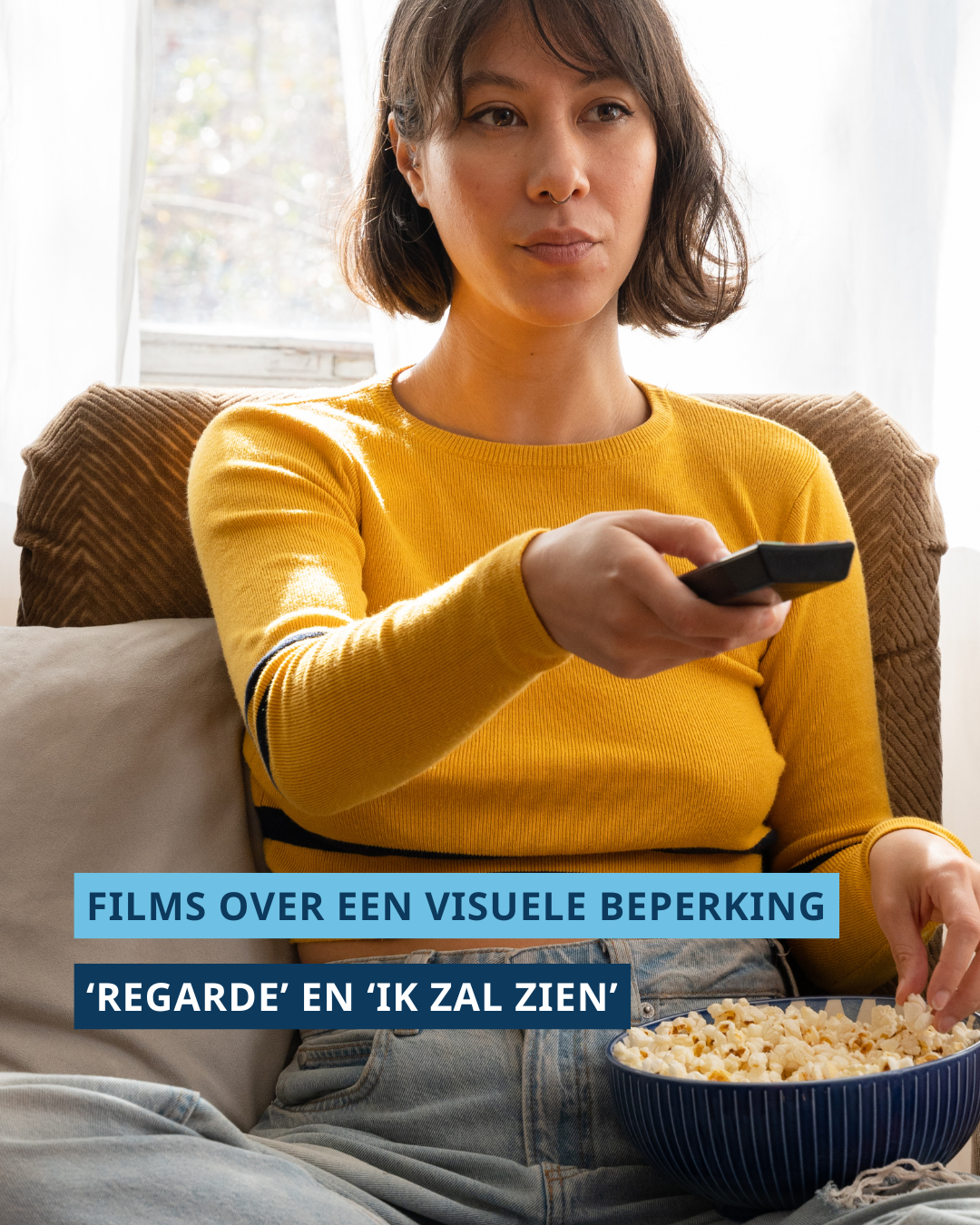 Een vrouw die op de bank zit. Ze kijkt voor zich uit met een afstandsbediening in haar hand en popcorn op haar schoot. Onderaan de foto staat de tekst ‘Films over een visuele beperking’ en ‘Regarde’ en ‘Ik zal zien’