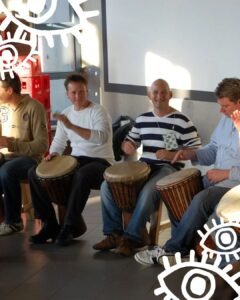 Mensen spelen lachend Djembé tijdens een Djembé-workshop van Dununba