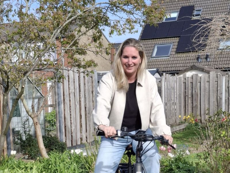 Gabriëlle den Hollander-Beijer zit op haar fiets in de tuin