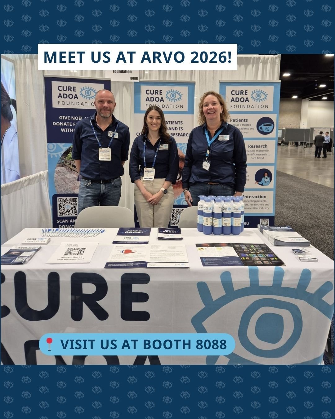 Een foto van Richard, Olivia en Hedy van de Cure ADOA Foundation in hun stand op het ARVO-congres. Ze staan achter een tafel met informatiemateriaal en voor banners van de stichting. De afbeelding bevat de tekst ‘MEET US AT ARVO 2026!’ en ‘VISIT US AT BOOTH 8088’.