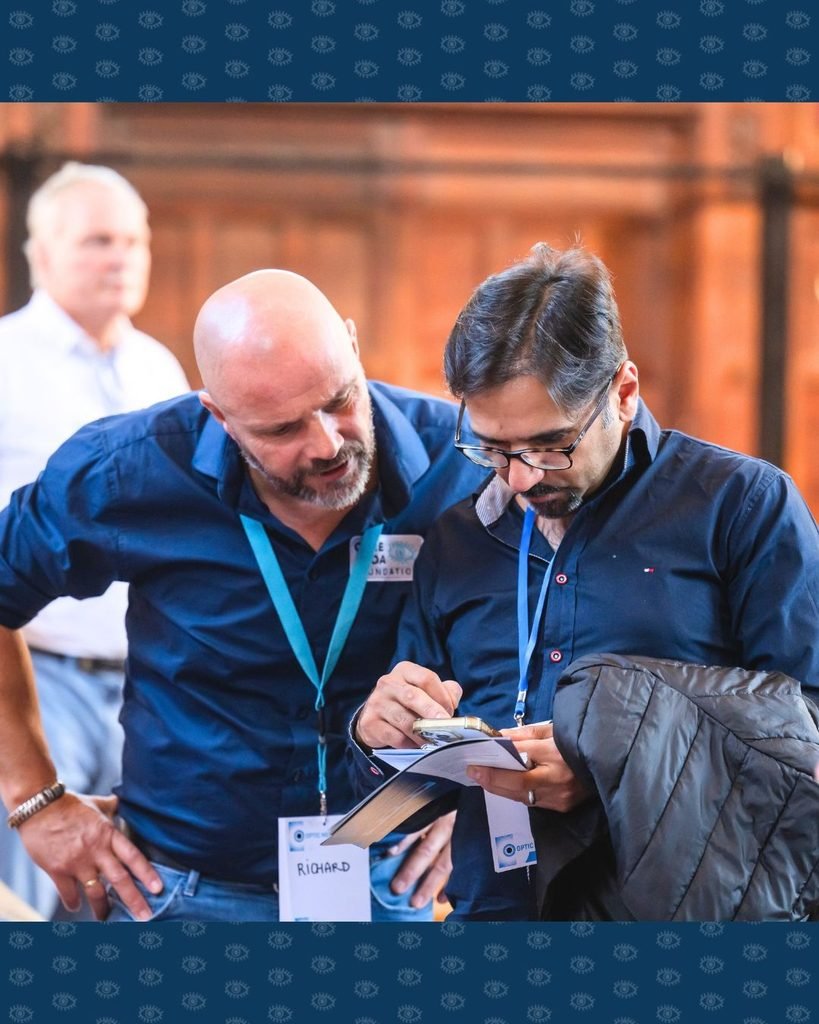 Vrijwilliger Richard bespreekt voorlichtingsmateriaal met andere bezoeker Optic Nerve Forum