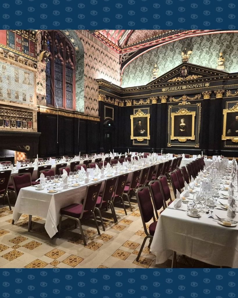 De gedekte tafels voor het diner in de Queen's College zaal