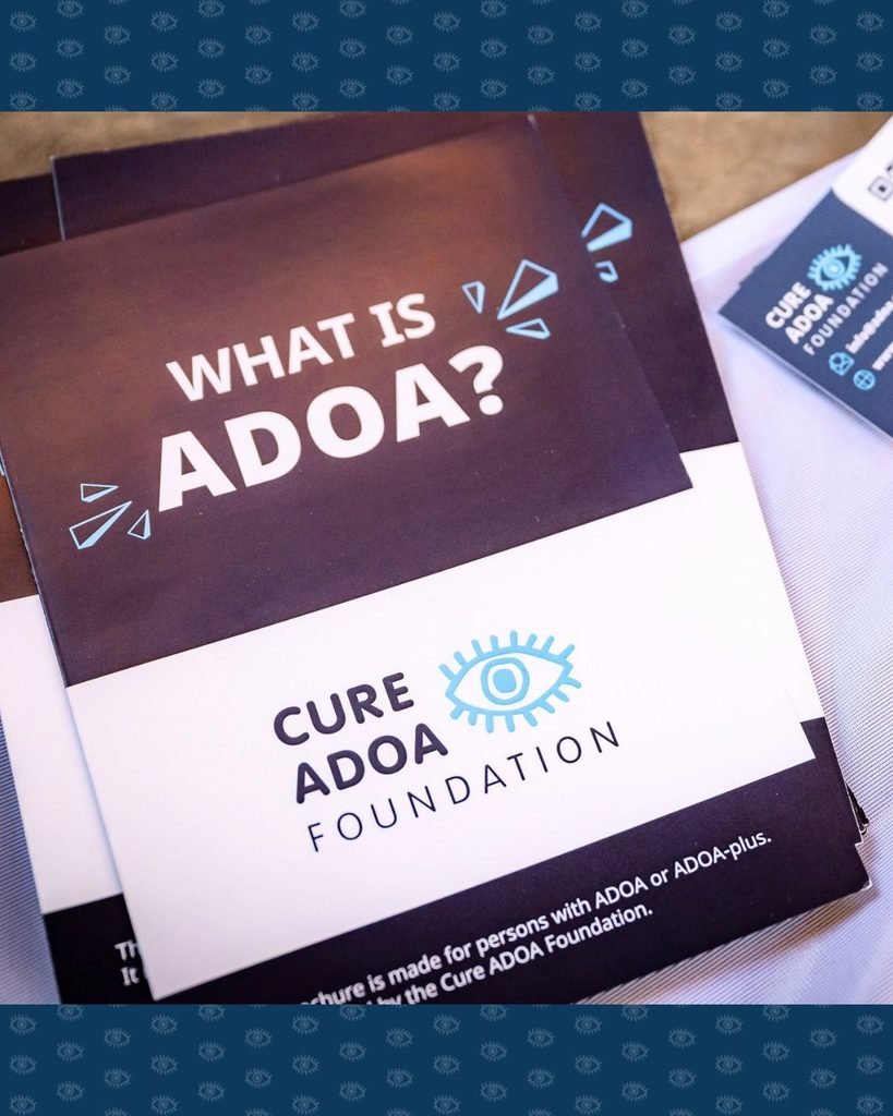Een stapel 'What is ADOA?' folders op de tafel van de stand